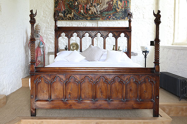 Unique Gothic style carved oak bed against chapel altar