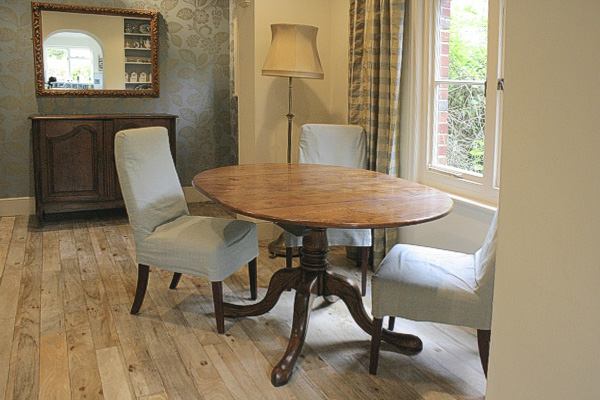 Extending solid oak oval table in dining room of Sussex downland village house